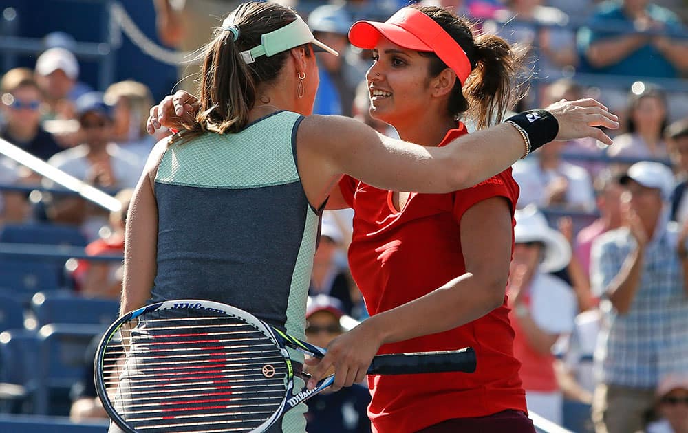 Martina Hingis of Switzerland, left, and partner Sania Mirza, of India, celebrate after winning their doubles match during the fourth round of the U.S. Open tennis tournament.