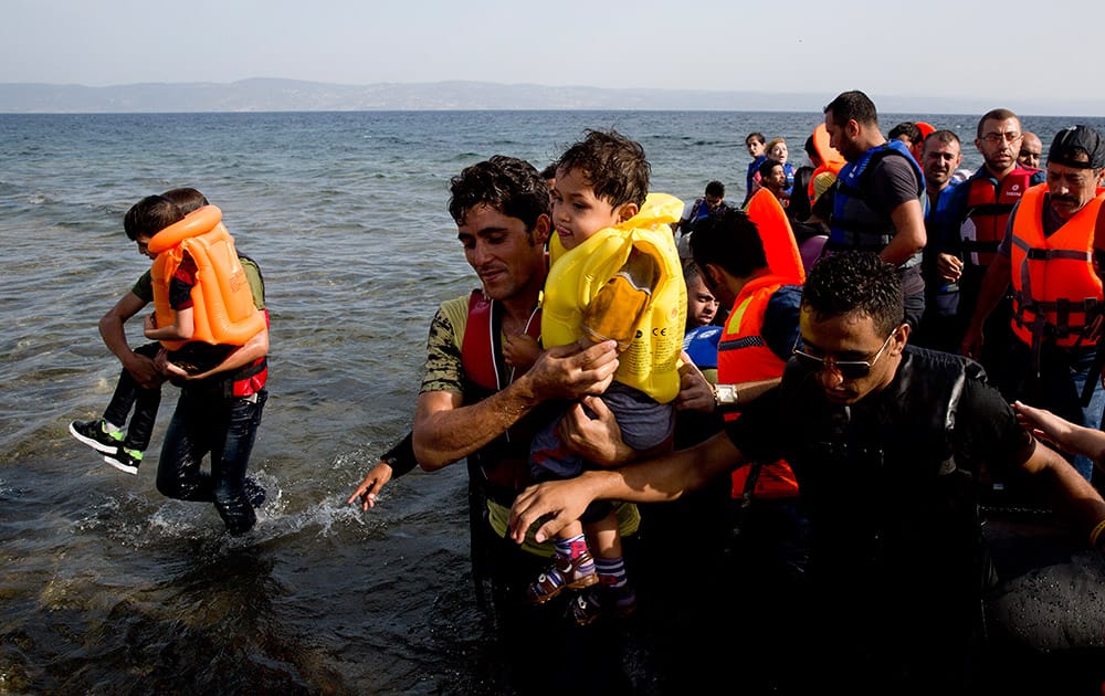 Syrian migrants arrive at the coast on a dinghy after crossing from Turkey, at the island of Lesbos, Greece.