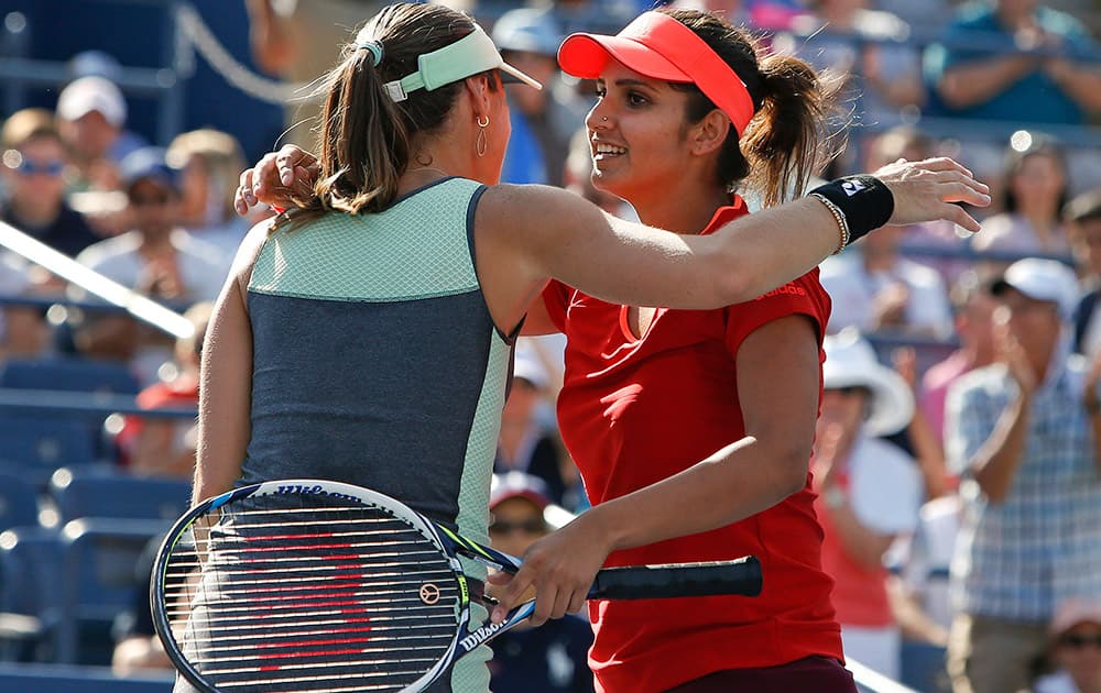 Martina Hingis of Switzerland and partner Sania Mirza, of India, celebrate after winning their doubles match during the fourth round of the U.S. Open tennis tournament.