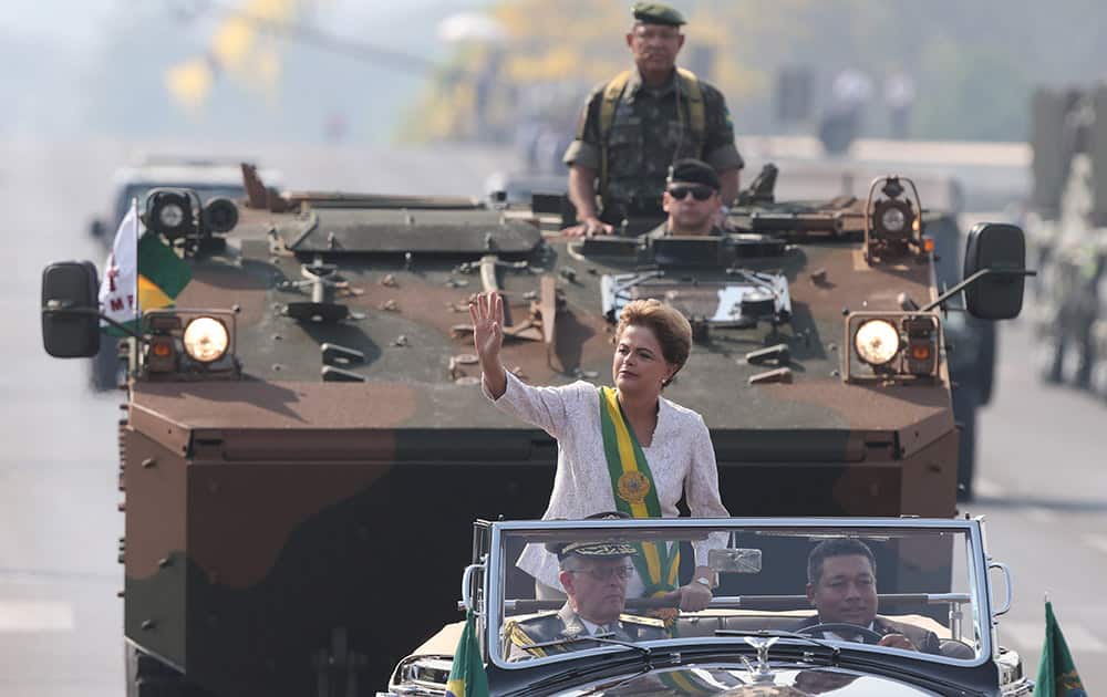 Brazil’s President Dilma Rousseff waves from an open car during military celebrations marking Brazil’s Independence Day, in Brasilia, Brazil.