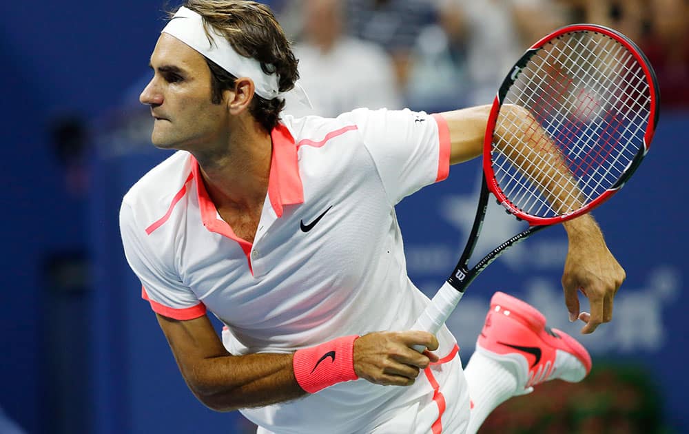 Roger Federer, of Switzerland, follows through on a serve during his fourth round match against John Isner at the U.S. Open tennis tournament in New York.