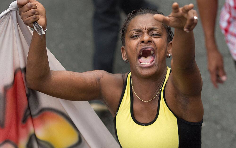 A woman shouts slogans as she takes part in a march organized by a variety of social movements in favor of democracy and human rights, in Sao Paulo, Brazil.