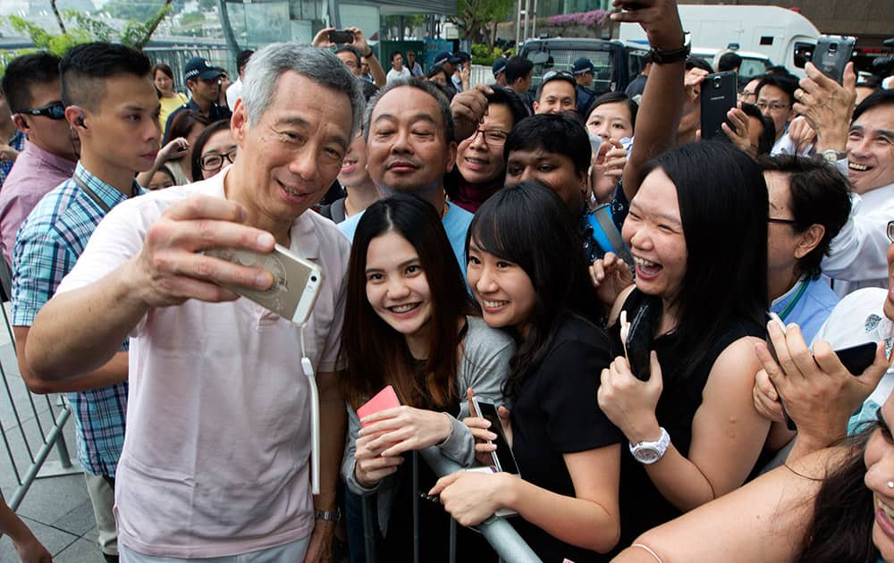 Singaporean Prime Minister Lee Hsien Loong poses with residents for a selfie after attending a rally for the ruling People's Action Party in downtown Singapore.