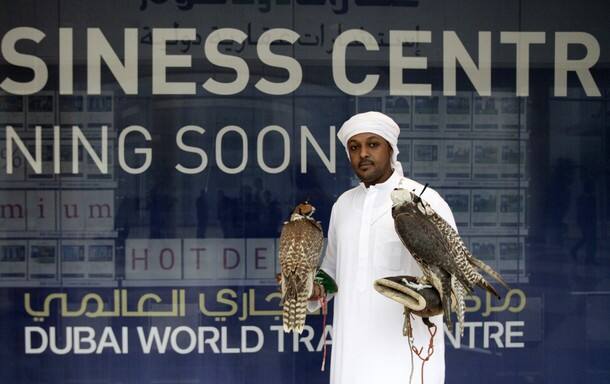 A man carries falcons on his way to the Arabian Travel Markt Exhibition 