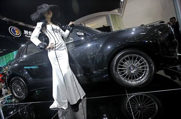 A model poses next to a Geely Englon TXN car 