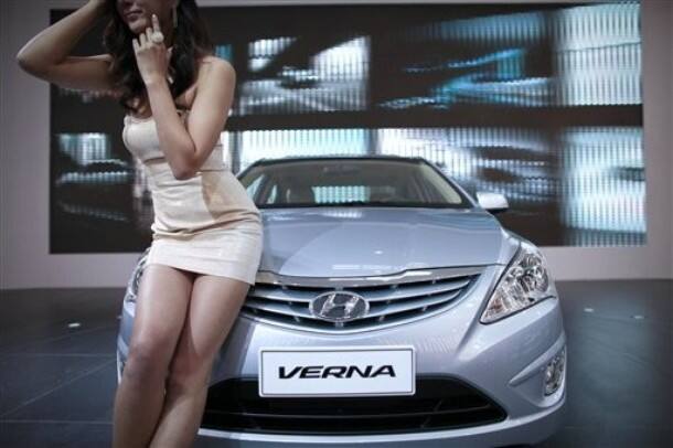 A model poses for photos with a Hyundai Verna 