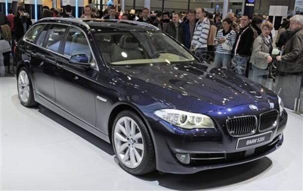 Visitors stand besides the new BMW 5 Series 