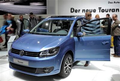 Visitors inspect a new Volkswagen VW Touran during the AMI Leipzig Car Fair 2010 
