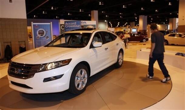 Workers center a 2010 Accord Crosstour on a turntable in the Honda display at the show