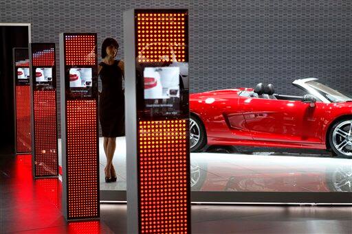 A model stands near cars 