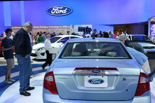 People look at a new Ford vehicle on the opening day of the New York International Auto Show