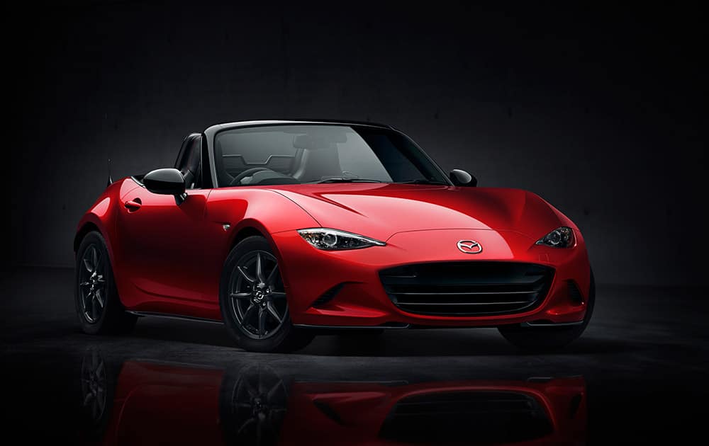 This photo provided by Mazda North America Operations shows the exterior front and side view of the new 2016 Mazda MX-5 Miata. Twenty-six years after the debut of the first Miata, Mazda is introducing the fourth generation of the popular soft-top convertible. 