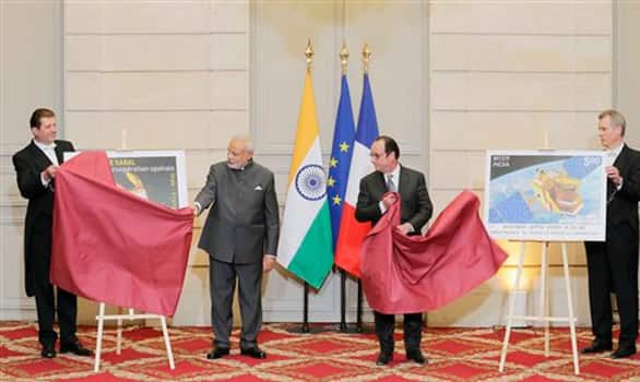 Prime Minister Narendra Modi and French President Francois Hollande unveil a new official postage stamp at the Elysee Palace, in Paris.