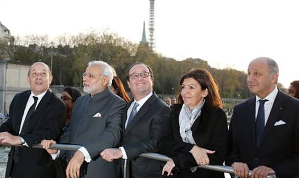 Prime Minister Narendra Modi, second left, French President Francois Hollande, center, Defence Minister Jean-Yves Le Drian, left, Mayor Anne Hidalgo and Foreign Affairs Minister Laurent Fabius enjoy a tour on the Seine River, past the Eiffel Tower, on a tour boat in Paris.