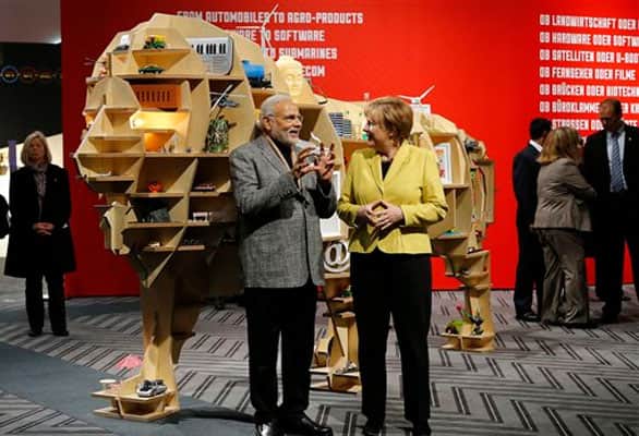 German Chancellor Angela Merkel and India's Prime Minister Narendra Modi, left, chat at the India booth during the opening of the industrial fair in Hanover, Germany, Monday, April 13, 2015.