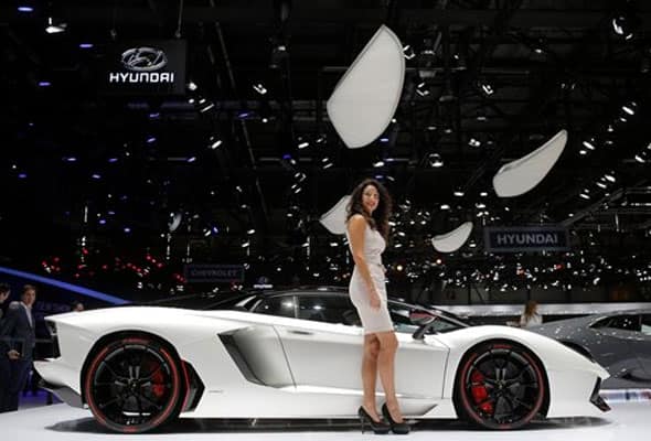 A model poses in front of the new Lamborghini Aventador during the first press day of the Geneva International Motor Show Tuesday, March 3, 2015 in Geneva, Switzerland.
