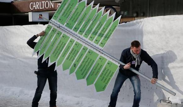 Technicians setting up signs outside the Congress Hall in Davos, Switzerland, Monday, Jan. 19, 2015.