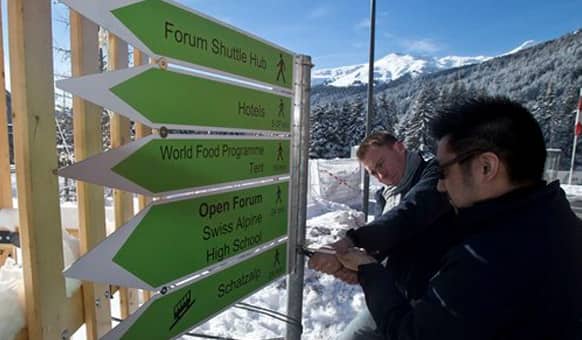 Technicians setting up signs outside the Congress Hall in Davos, Switzerland, Monday, Jan. 19, 2015.