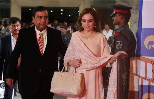 Reliance Industries chairman Mukesh Ambani, left and his wife Nita Ambani arrive for the company's annual general meeting in Mumbai, India, Wednesday, June 18, 2014. 