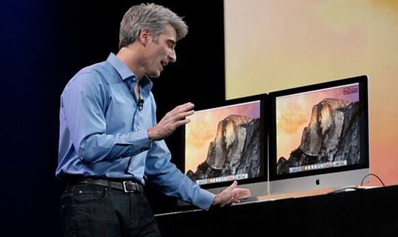 Apple senior vice president of software engineering Craig Federighi speaks over a computer to Beats co-founder Dr. Dre.