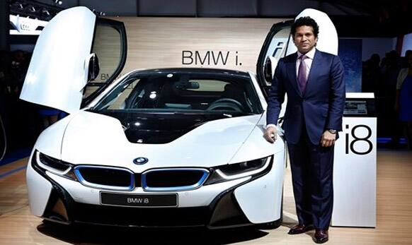 Indian cricket icon Sachin Tendulkar poses with a BMW i8 hybrid car at the 12th Indian auto Expo in Noida.