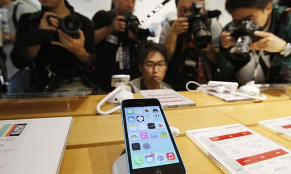 Photographers take pictures of Apple's new iPhones on display during a ceremony to mark the first day sales of the latest iPhones 5C and 5S at a store in Tokyo on Friday. 