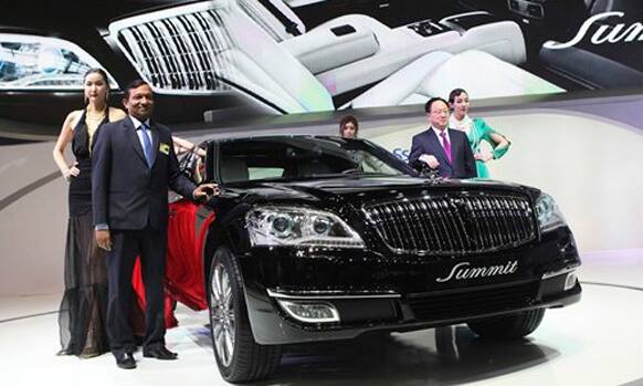 Pawan Kumar Goenka, president of Mahindra & Mahindra LMT., second from left, and Lee Yoo-Il, SsangYong Motor chief executive, second from right, pose with a Ssangyong's new model, 