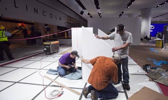 Lincoln auto crew members assemble display components in preparation for the 2013 North American International Auto Show in Detroit.