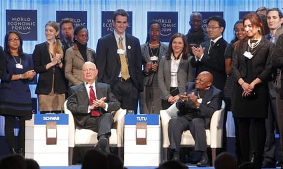 Klaus Schwab, founder of the World Economic Forum, left, and Archbishop Desmond Tutu, right, are surrounded by young global leaders during a session at the World Economic Forum in Davos.
