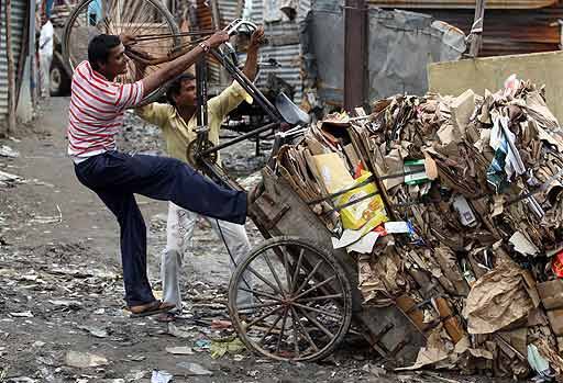 From rag to rubbish: Rag pickers try to right their overturned cycle rickshaw in New Delhi.
