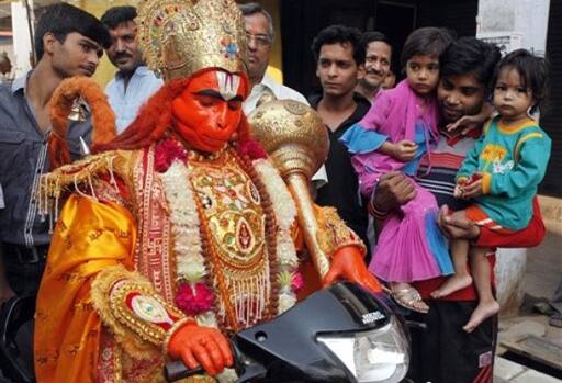 Monkey God: An Indian man dressed as a monkey god Hanuman sits on a scooter to bless its owner with good wishes as he participates in a procession as part of the Hindu festival of Hanuman Jayanti.