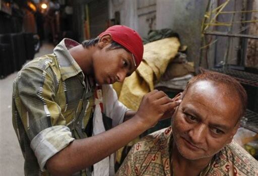 Music to ears: A man gets his ears cleaned by an ear cleaner on a street in New Delhi.