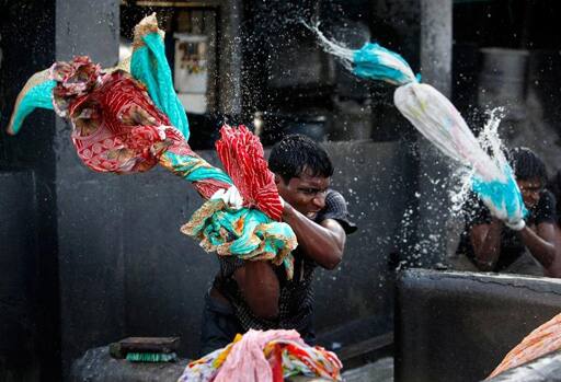 In sync: Laundrymen work at the Dhobi Ghat open air laundry in Mumbai. Termed as the world's largest outdoor laundry, Dhobi Ghat is where Mumbai's traditional laundrymen work in the open to wash clothes from different parts of the city. 