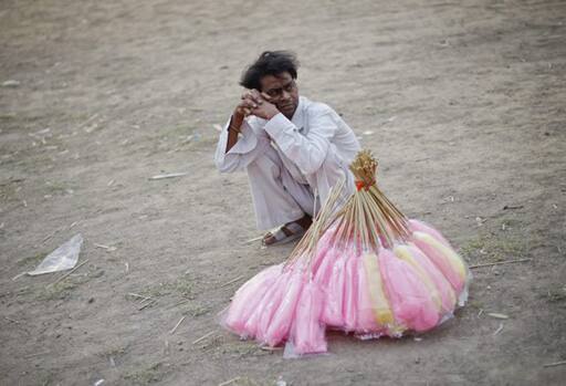 Candy man: A man waits for his customers to buy candyfloss from him near India Gate in New Delhi. 