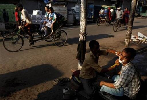 Shave by the roadside: A roadside barber gives a customer a shave in New Delhi.