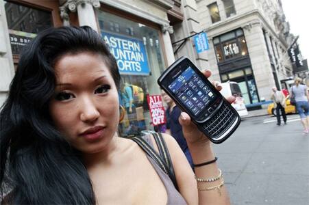 A woman shows off her new BlackBerry Torch 9800 outside an AT&T store in New York