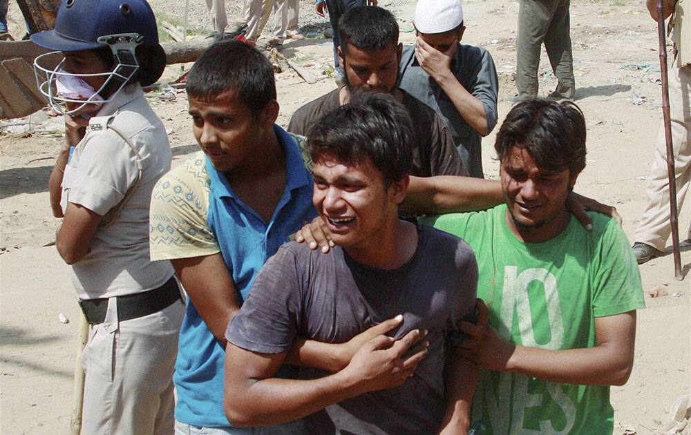 Residents react as authorities carry out a during a demolition drive against illegal encroachments, at Sarai Alawardi village in Gurgaon.