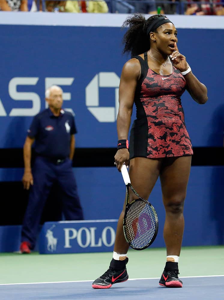 Serena Williams motions for quiet during a quarterfinal match against Venus Williams at the U.S. Open tennis tournament.