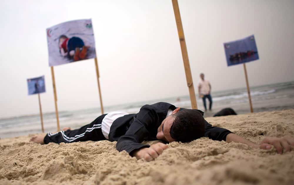 Palestinians act as dead Syrian migrants found on Libyan and Turkish coasts in support of migrants seeking better lives, during a demonstration at Gaza City's beach.