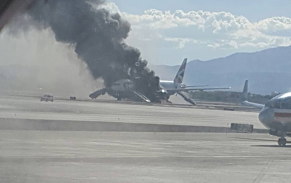 smoke billows out from a plane that caught fire at McCarren International Airport in Las Vegas. An engine on the British Airways plane caught fire before takeoff, forcing passengers to escape on emergency slides.