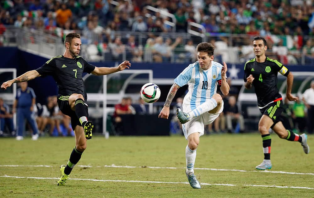 Argentina's Lionel Messi, controls the ball challenged by Mexico's Miguel Layun, left, during a friendly soccer match at the AT&T Stadium in Arlington, Texas.