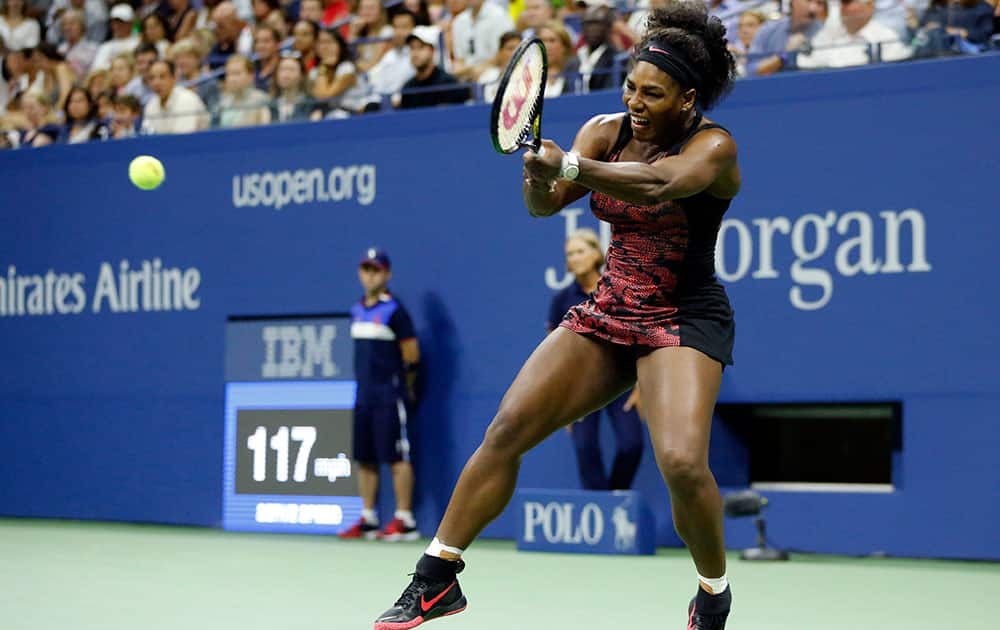 Serena Williams returns a shot to Venus Williams during a quarterfinal match at the US Open tennis tournament.