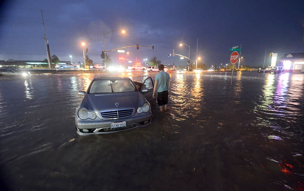 A motorist is stranded on Bear Valley Outerhighway South near Jacaranda Ave in Hesperia, Calif. The SUV in the left of the frame is the vehicle where a man exited his SUV and was swept into the storm drain and was later found alive at across the street at Victor Valley College lake in Victorville, Calif.