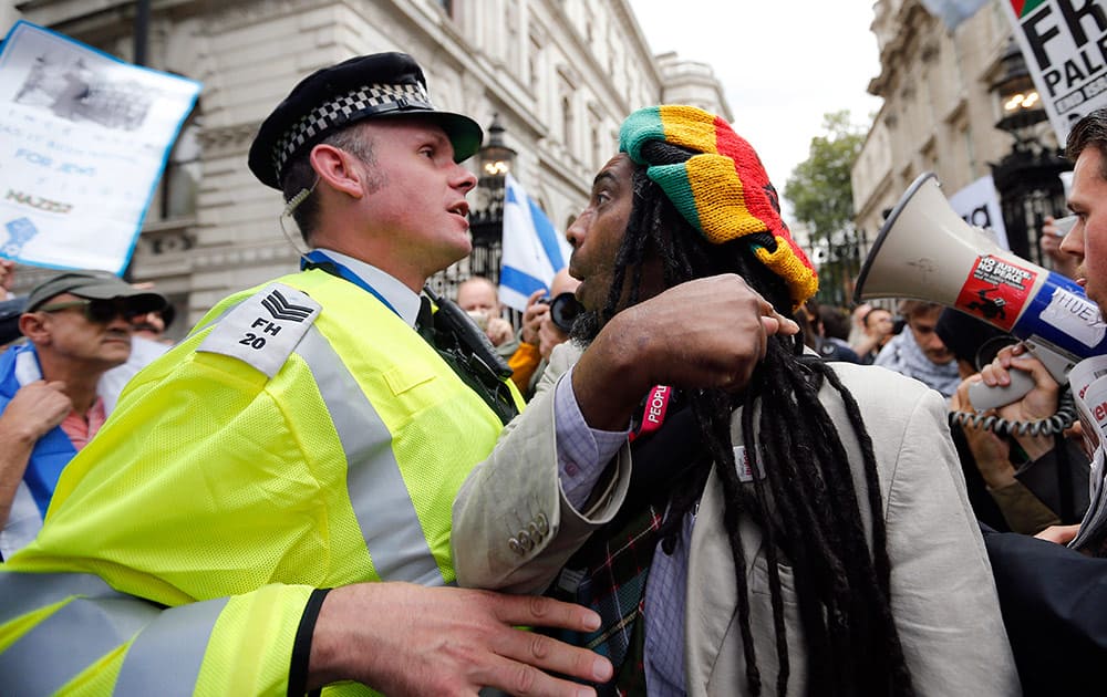 Police officers push back demonstrators during a protest against the visit of Israel's Prime Minister Benjamin Netanyahu to Britain, in front of Downing Street in London.