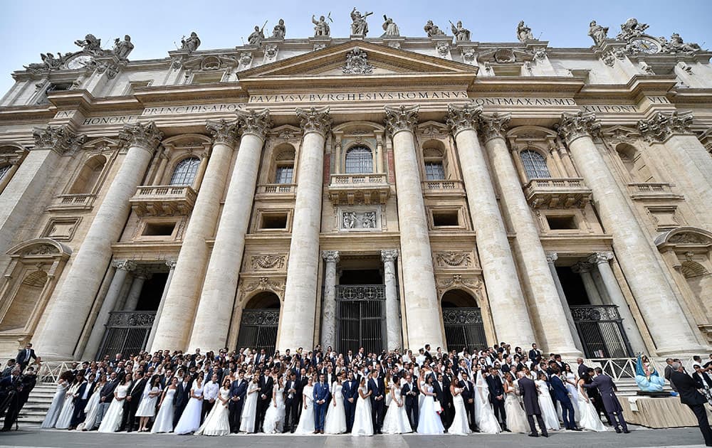 Newlywed couples stand in front of St. Peter's Basilica as they attend Pope Francis' weekly general audience, in St. Peter's Square at the Vatican.