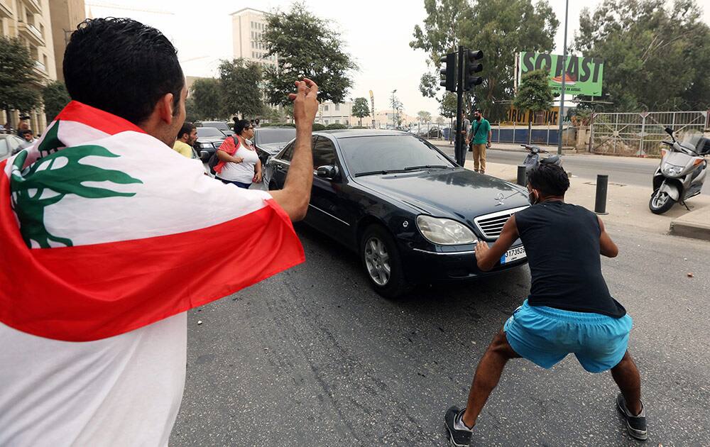 Lebanese anti-government protesters throw eggs and water bottles at the unknown convoy of a Lebanese politician leaving the parliament building, during a protest against the on-going trash crisis and government corruption, in downtown Beirut, Lebanon.