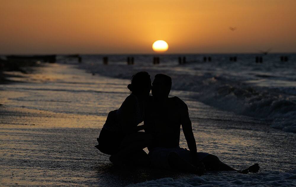 A couple enjoys the sunset at the beach in Manaure, Colombia.