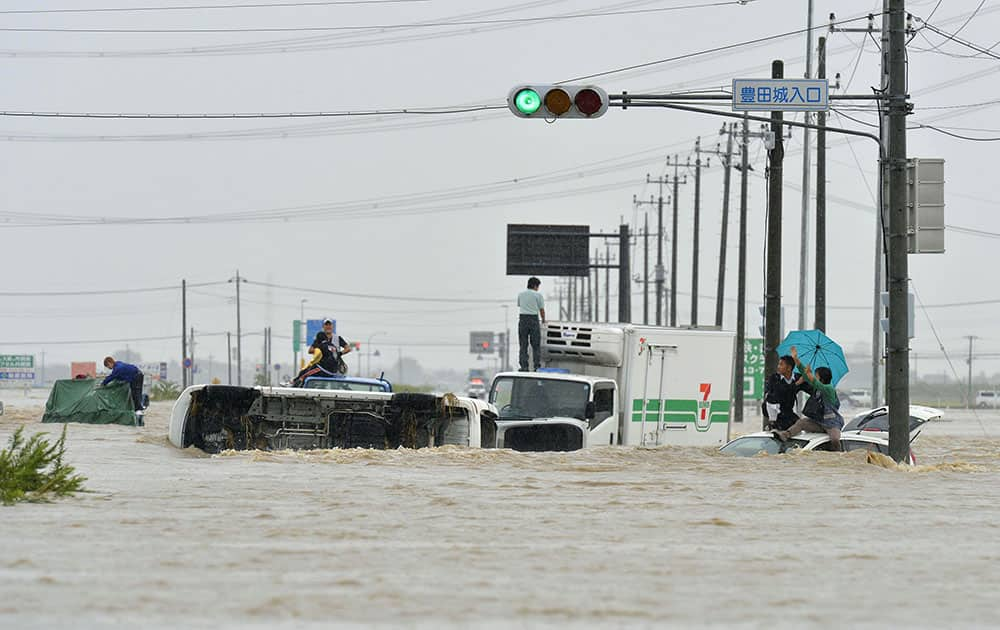 People wait for help as the vehicles are submerged in flooding in Joso, Ibaraki prefecture, northeast of Tokyo.