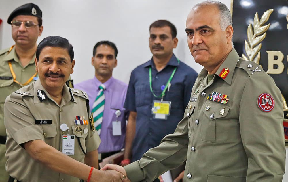 Indian Border Security Force (BSF) Director General D.K. Pathak and Pakistani Rangers Director General (Punjab) Maj Gen Umar Farooq Burki shake hands as they pose for photographs before the start of their delegation level meeting in New Delhi.