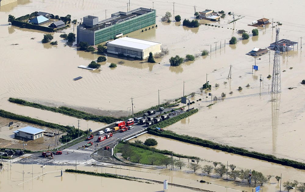 Vehicles of the Ground Self-Defense Force and firefighters are parked at a partially submerged road during a rescue operation in Joso, Ibaraki prefecture, northeast of Tokyo.